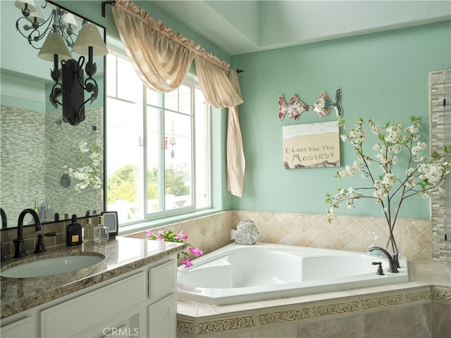 bathroom featuring vanity and tiled bath