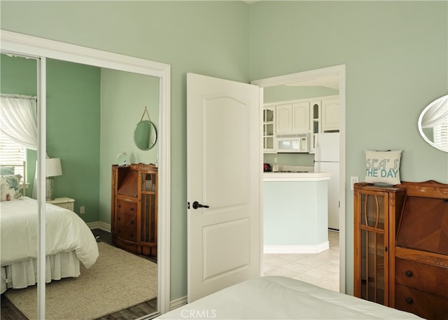 tiled bedroom with white refrigerator and a closet