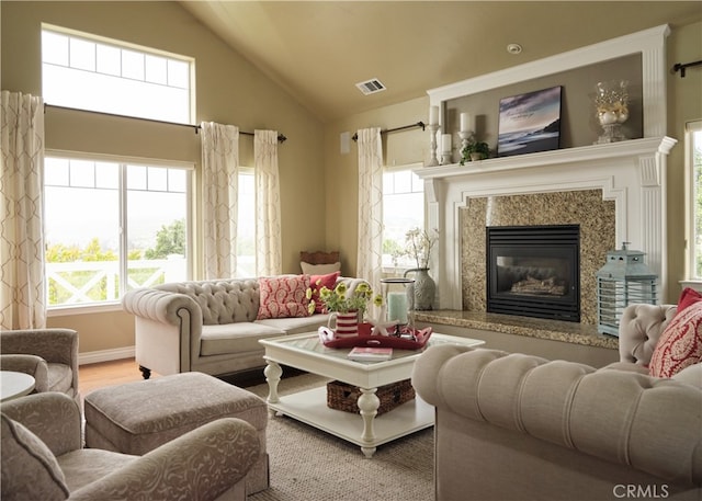 living room with wood-type flooring, a high end fireplace, and high vaulted ceiling