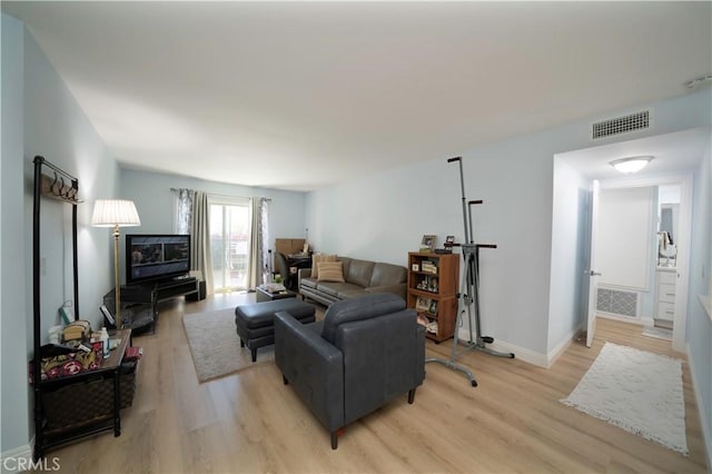 living room featuring light wood-type flooring, baseboards, and visible vents