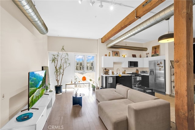 living room with wood-type flooring and beamed ceiling