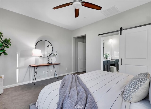 bedroom featuring dark colored carpet, ceiling fan, and a barn door