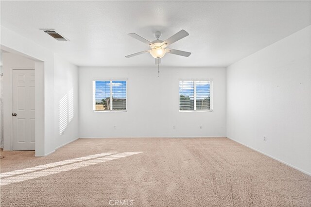 carpeted spare room with ceiling fan