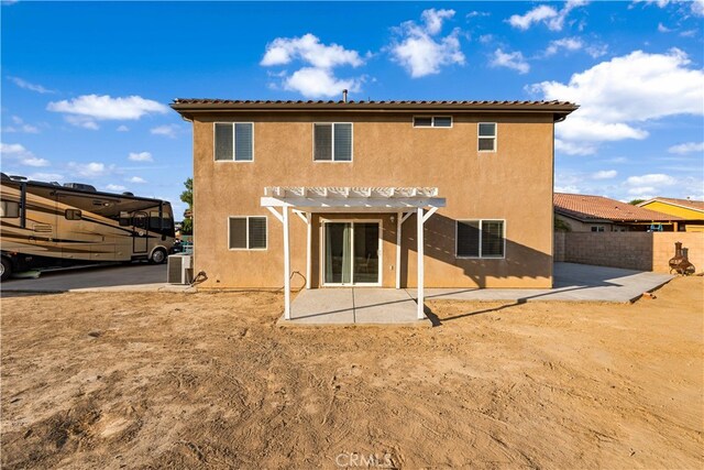 rear view of house with central AC unit, a pergola, and a patio area