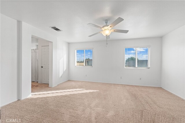 carpeted spare room featuring a textured ceiling and ceiling fan