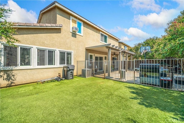 rear view of property with stucco siding, fence, a patio, a lawn, and ceiling fan
