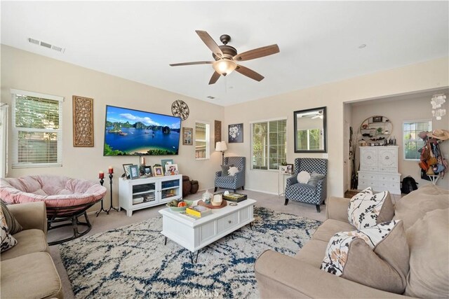 carpeted living room featuring ceiling fan and a healthy amount of sunlight