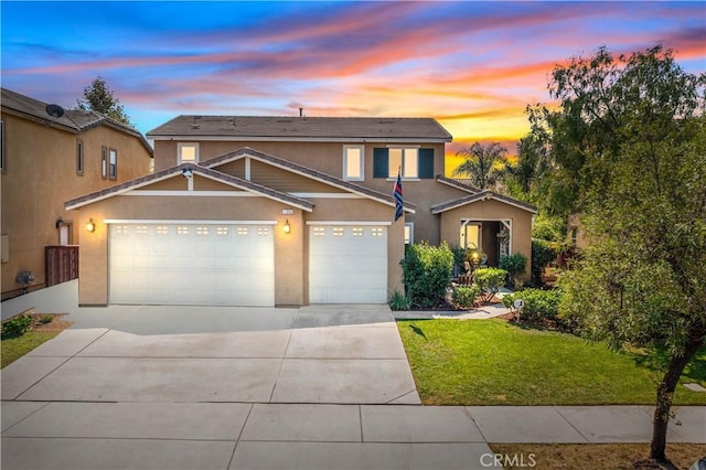 traditional-style house with a front lawn, driveway, stucco siding, and a garage