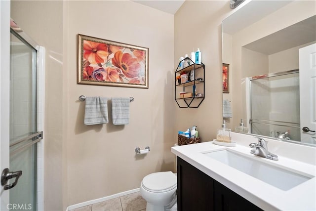 bathroom with tile patterned flooring, vanity, a shower with shower door, and toilet