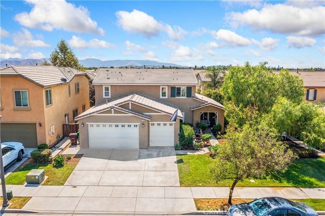 view of front of house with stucco siding, an attached garage, a mountain view, and concrete driveway