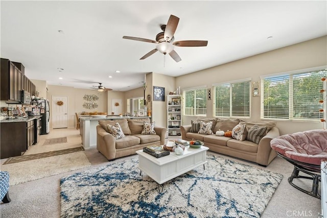 living room featuring light carpet and ceiling fan