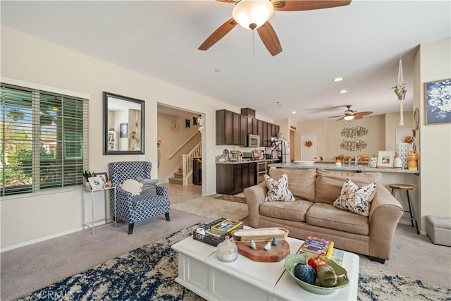 living room featuring stairs, recessed lighting, baseboards, a ceiling fan, and light carpet