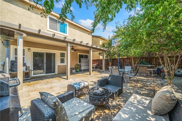 view of patio featuring ceiling fan and an outdoor living space with a fire pit