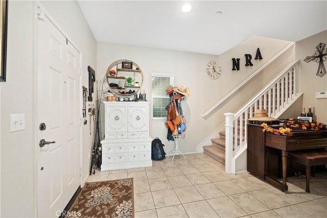 entryway with light tile patterned flooring and stairway