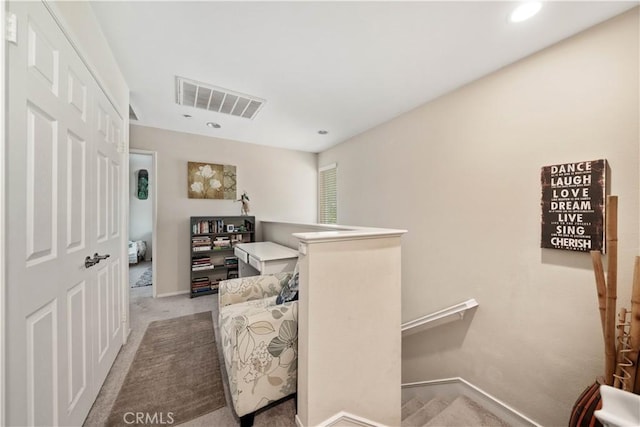 living area with baseboards, visible vents, an upstairs landing, and carpet floors