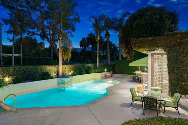 view of pool featuring exterior bar and a patio