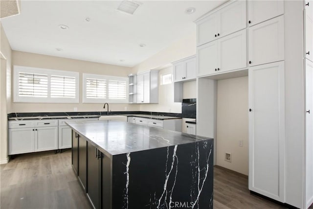 kitchen with white cabinetry, a center island, and dark hardwood / wood-style floors