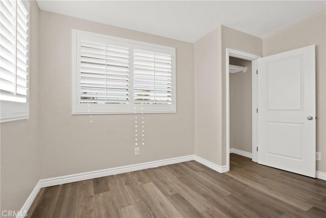 unfurnished bedroom with multiple windows, hardwood / wood-style floors, and a closet