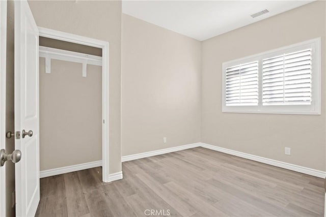 unfurnished bedroom with a closet and light hardwood / wood-style flooring