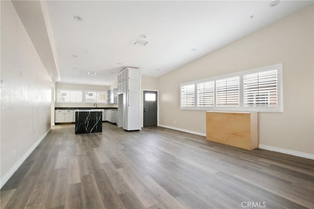 unfurnished living room featuring hardwood / wood-style floors, a healthy amount of sunlight, and vaulted ceiling