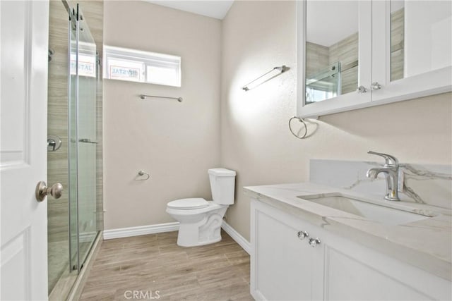 bathroom with vanity, toilet, and a shower with shower door