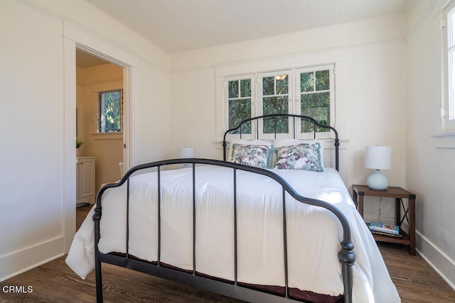 bedroom with dark hardwood / wood-style floors and ensuite bathroom