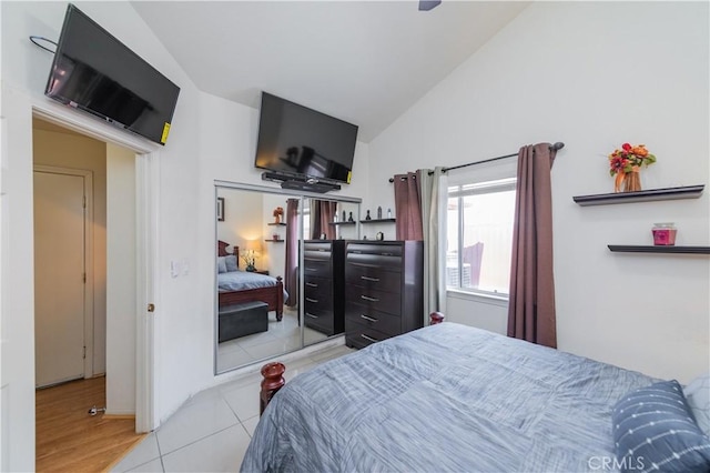 tiled bedroom with a closet and lofted ceiling