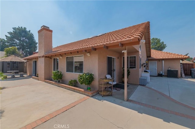 rear view of house with a patio area and central air condition unit