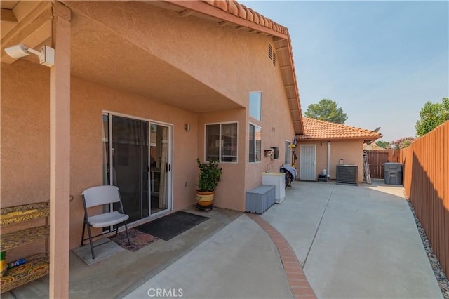 rear view of house featuring a patio and central AC