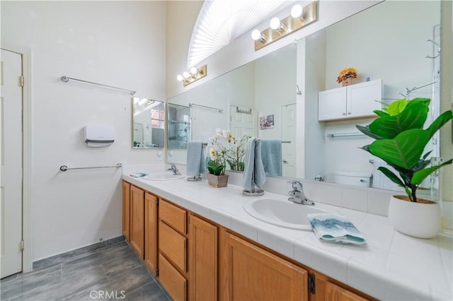 bathroom with vanity, toilet, and a towering ceiling