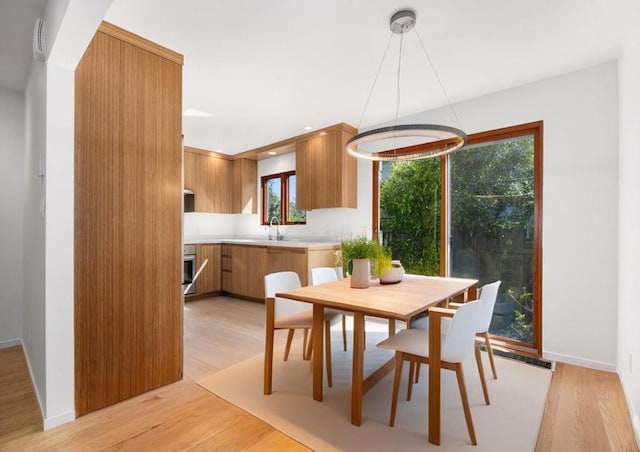 dining space featuring light wood-type flooring and sink