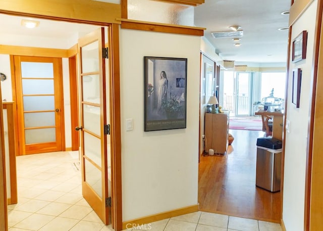 corridor with french doors and light wood-type flooring