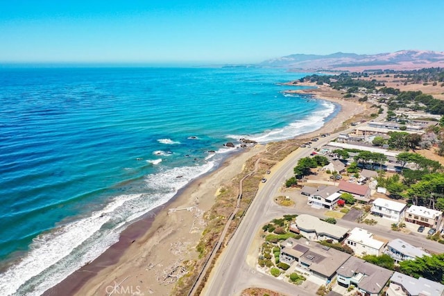 aerial view with a water and mountain view and a view of the beach