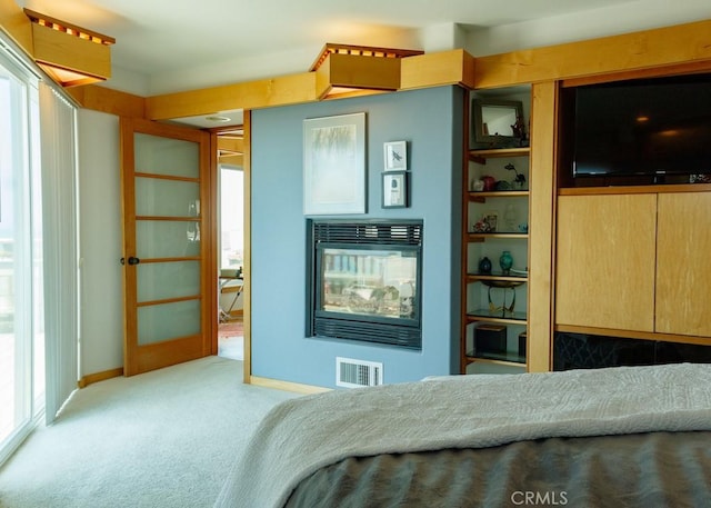 carpeted bedroom featuring multiple windows