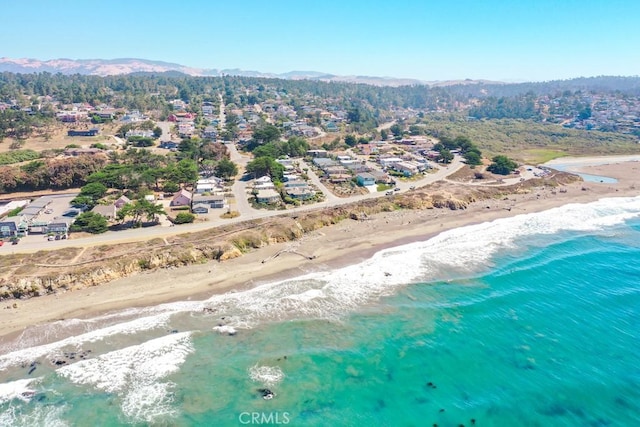 drone / aerial view with a beach view and a water and mountain view