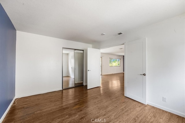 interior space with a textured ceiling and hardwood / wood-style flooring