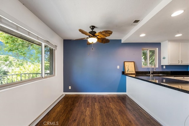 kitchen featuring ceiling fan, white cabinets, sink, dark stone counters, and dark hardwood / wood-style flooring