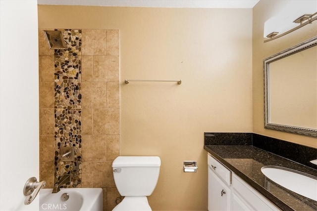 full bathroom featuring vanity, tiled shower / bath combo, and toilet