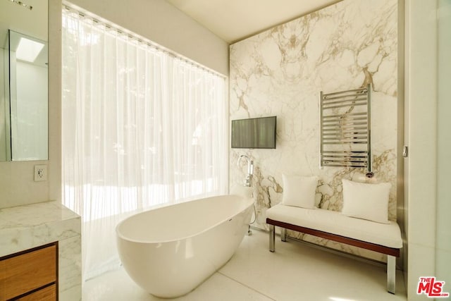 bathroom with a washtub, radiator heating unit, tile walls, and vanity