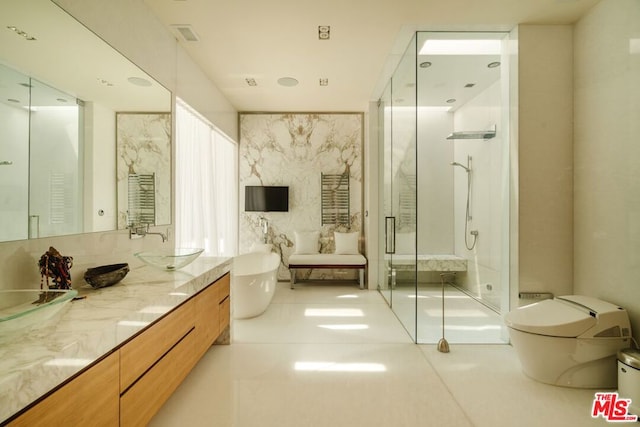 full bathroom featuring tile patterned floors, vanity, shower with separate bathtub, and toilet