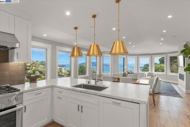 kitchen with stainless steel range oven, plenty of natural light, and white cabinetry