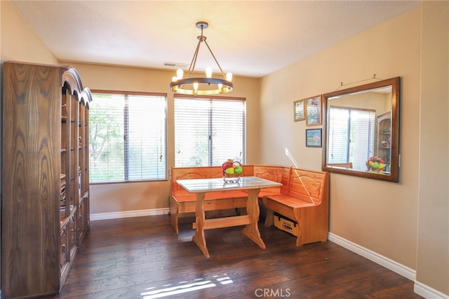 dining space with a textured ceiling, a chandelier, and dark wood-type flooring