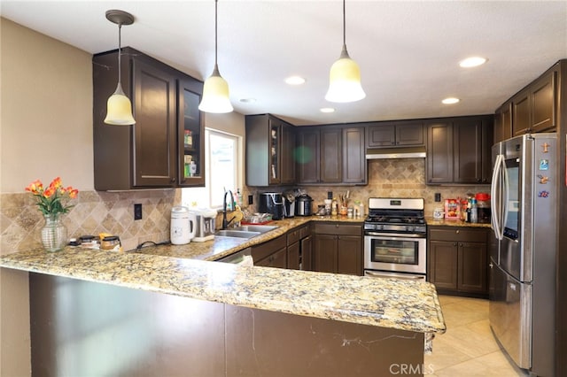 kitchen featuring pendant lighting, sink, kitchen peninsula, backsplash, and appliances with stainless steel finishes