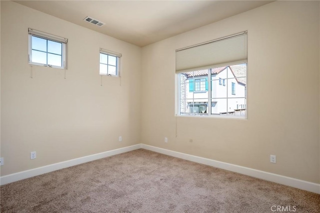 carpeted spare room with visible vents and baseboards