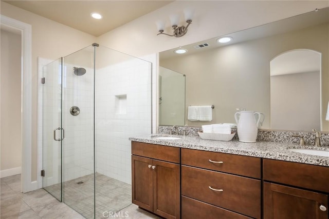 full bathroom with a sink, visible vents, double vanity, and a shower stall