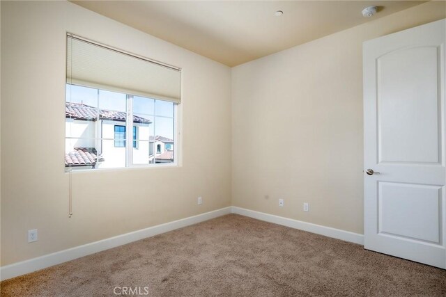 carpeted spare room with baseboards