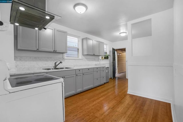 kitchen featuring sink, island exhaust hood, range with electric cooktop, gray cabinets, and light hardwood / wood-style floors