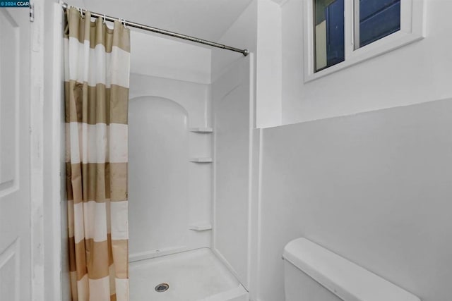 bathroom with toilet and curtained shower