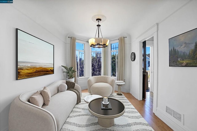 living room featuring light hardwood / wood-style floors and an inviting chandelier