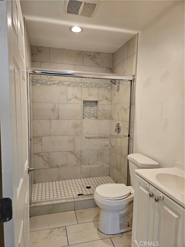 bathroom with visible vents, toilet, a stall shower, and vanity